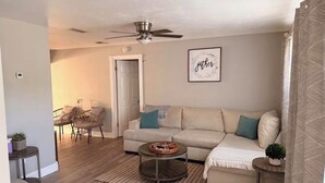 A living room with a beige sofa, a round coffee table, and a ceiling fan. - 3-bedroom vacation home just 9 minutes from Port Canaveral (Merritt Island)