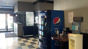 A checkered floor, vending machines, a water dispenser, and a wall with a menu. - Nechako Valley Inn  (Vanderhoof)