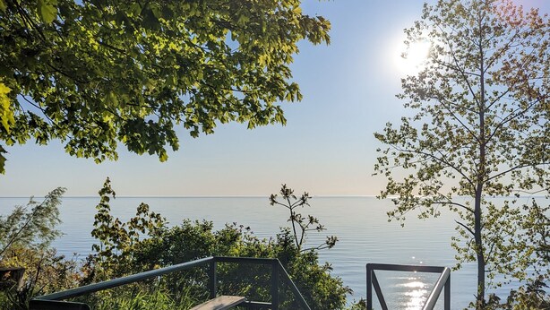A wooden deck leading to a beach with a sign indicating private beach rules. - Cozy Pet Friendly Cottage, Partial Water View, Sleeps 7, Half Block from Beach! (Lexington)