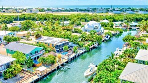 Zona costera con puerto deportivo, casas y un río.