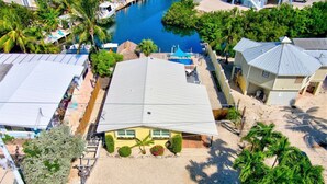 Una propiedad costera con una casa grande, un muelle y una piscina.