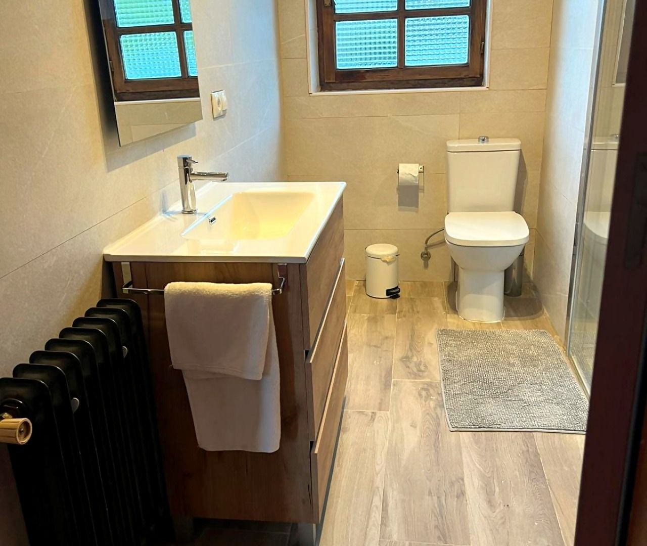 A bathroom with a sink, toilet, and a shower area.