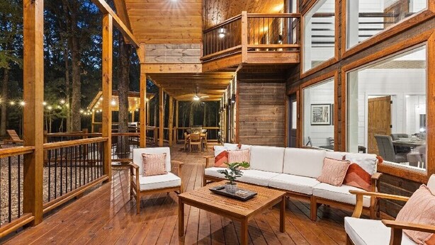 A spacious wooden deck with a white sofa and chairs, a wooden coffee table, and a balcony with a railing. - ✨Hampton's Hideaway: Luxury cabin with 🎲 Games, 🪁 Playground, and 💦 Hot Tub✨ (Broken Bow)