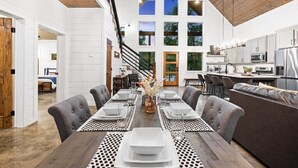 A modern dining area with a wooden table set for six, surrounded by grey upholstered chairs. - ✨Hampton's Hideaway: Luxury cabin with 🎲 Games, 🪁 Playground, and 💦 Hot Tub✨ (Broken Bow)