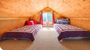 A cozy attic bedroom with two beds, a window with curtains, and a lamp. - RELAX - HOT TUB & GORGEOUS MOUNTAIN VIEWS                                    (Amherst)