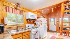 A wooden interior with a kitchen area including a stove, microwave, sink, and refrigerator. - RELAX - HOT TUB & GORGEOUS MOUNTAIN VIEWS                                    (Amherst)