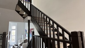 A modern interior with a wooden staircase, a white sofa, and a painting on the wall. - Waterfront home w/beach, pool, and tennis. 5 min to Blue Mountain.  (Collingwood)