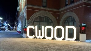 A large illuminated sign spelling "CWOOD" in front of a building with arched windows and brick walls. - Waterfront home w/beach, pool, and tennis. 5 min to Blue Mountain.  (Collingwood)