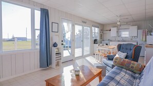Ein gemütliches Zimmer mit einer Couch, einem Holztisch und einer Küchenzeile.