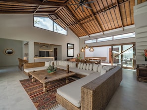 Relax in this stylish living area with a large sofa, wooden coffee table, and dining space.