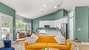 Una sala de estar con un sofá amarillo, un sillón azul y una mesa de centro.