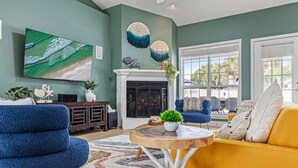 Una sala de estar con chimenea, televisor y sofá.