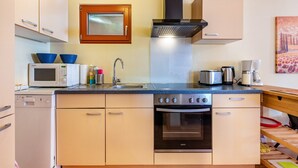 A compact kitchen with a microwave, toaster, kettle, and oven. - Holiday Apartment "Hach" with Private Terrace & Wi-Fi (Sulzburg)