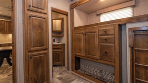 A hallway with wooden cabinetry, a sink, and a decorative wall panel. - Far West RV Park and Cabins (Forks)