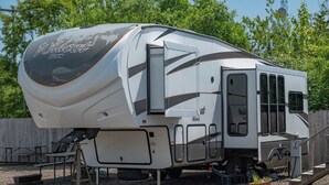 A recreational vehicle (RV) with a large awning and a covered kitchen area. - Far West RV Park and Cabins (Forks)