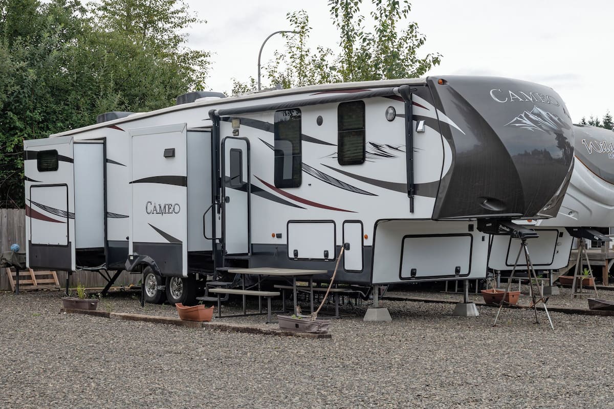 A large recreational vehicle with a covered living area, a kitchen, and a bathroom.