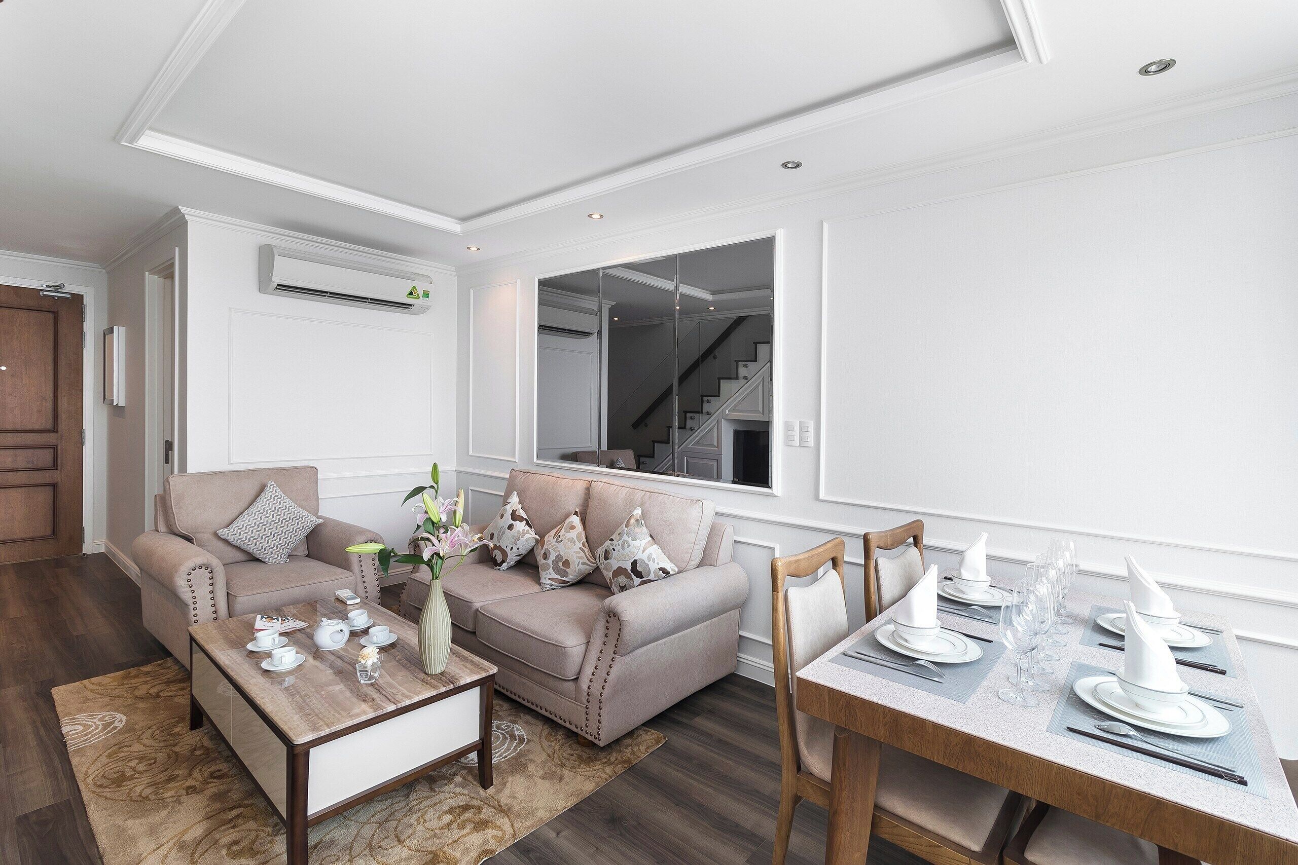 Un salon moderne avec un canapé, une table basse et une table à manger, le tout disposé pour un repas.