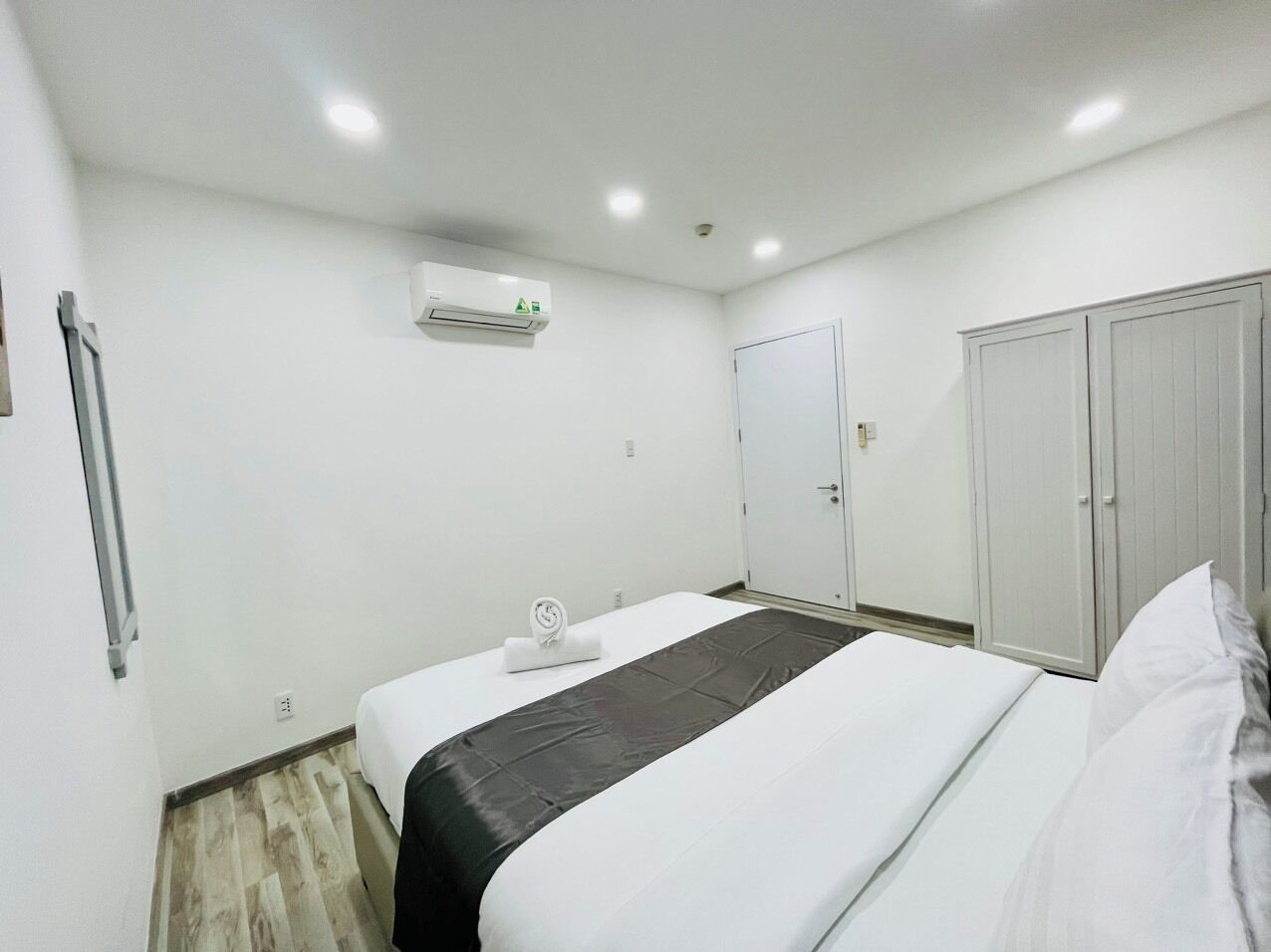 Une chambre d’hôtel équipée d’un lit, d’une armoire, d’une porte et d’un appareil de climatisation.