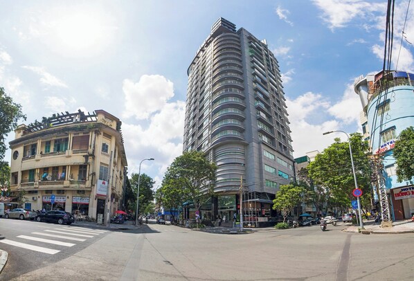 A multi-story hotel with a modern design, located at a busy urban intersection.