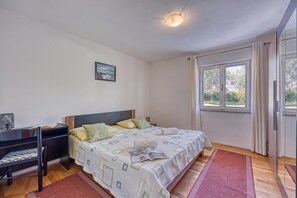 A bedroom with a bed, a desk, a chair, a window, and a door. - Pool House Lilly, Višnjan, Croatia (Višnjan)