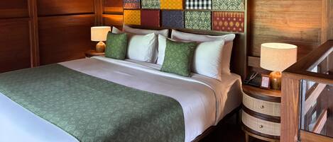 A neatly made bed with a patterned headboard, a bedside table with a lamp, and a wooden nightstand.