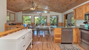 A spacious kitchen with wooden cabinets, a central island, and a dining area. - Adalee - Table Rock Lake, Roaring River, Eureka Springs, Dogwood Canyon (Eagle Rock)