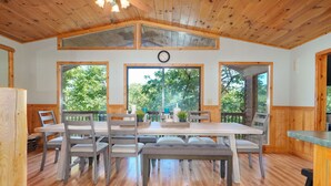 A wooden dining area with a large table, benches, and chairs. There are large windows with a view of greenery outside. - Adalee - Table Rock Lake, Roaring River, Eureka Springs, Dogwood Canyon (Eagle Rock)