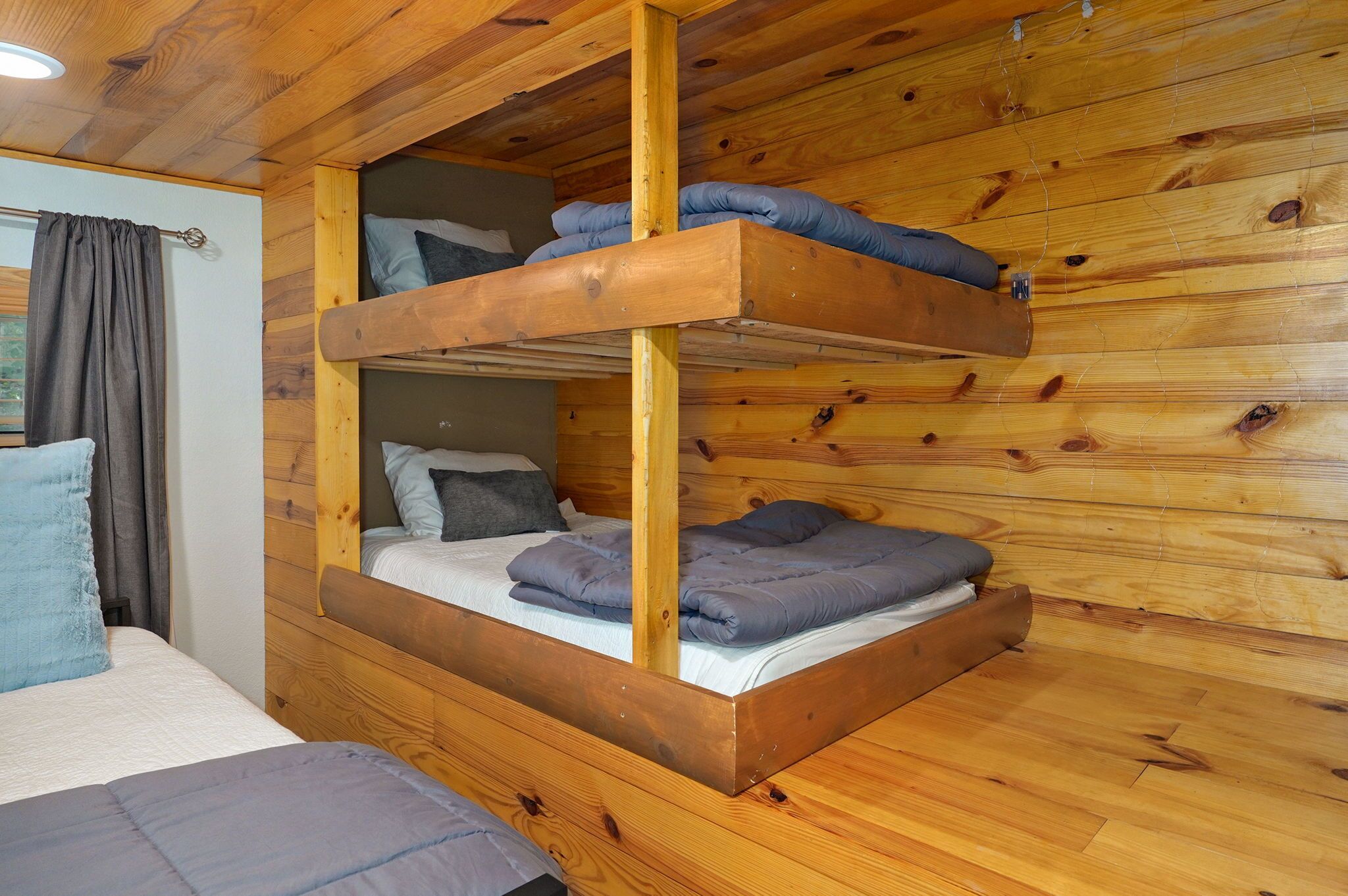 A bunk bed with a wooden frame and a lower bunk.