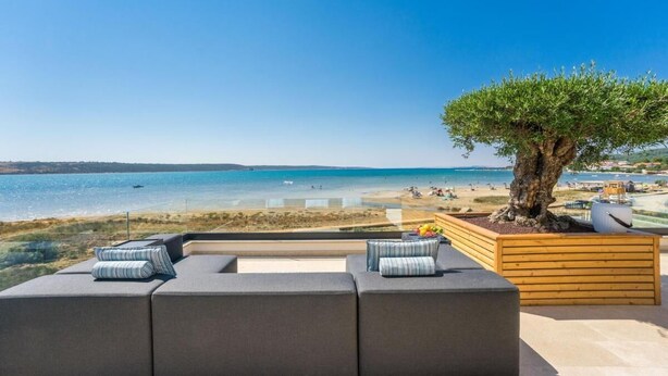 A modern outdoor seating area with a view of a beach and ocean. - Villa Four Seasons Ljubac Seaside (Ražanac)