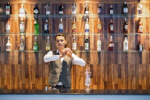 Un bar avec de nombreuses étagères remplies de bouteilles d’alcool.