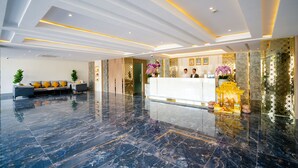 A modern lobby with a reception desk, seating area, and decorative elements. - Munich Hotel (Sihanoukville)
