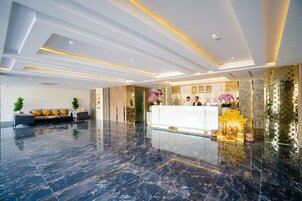A modern lobby with a reception desk, seating area, and decorative elements.