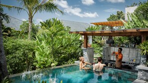 A pool area with a bar and lush tropical plants. - Inara Alas Harum (Payangan)