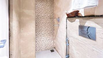 A bathroom with a shower, a towel rack, and a mirror.