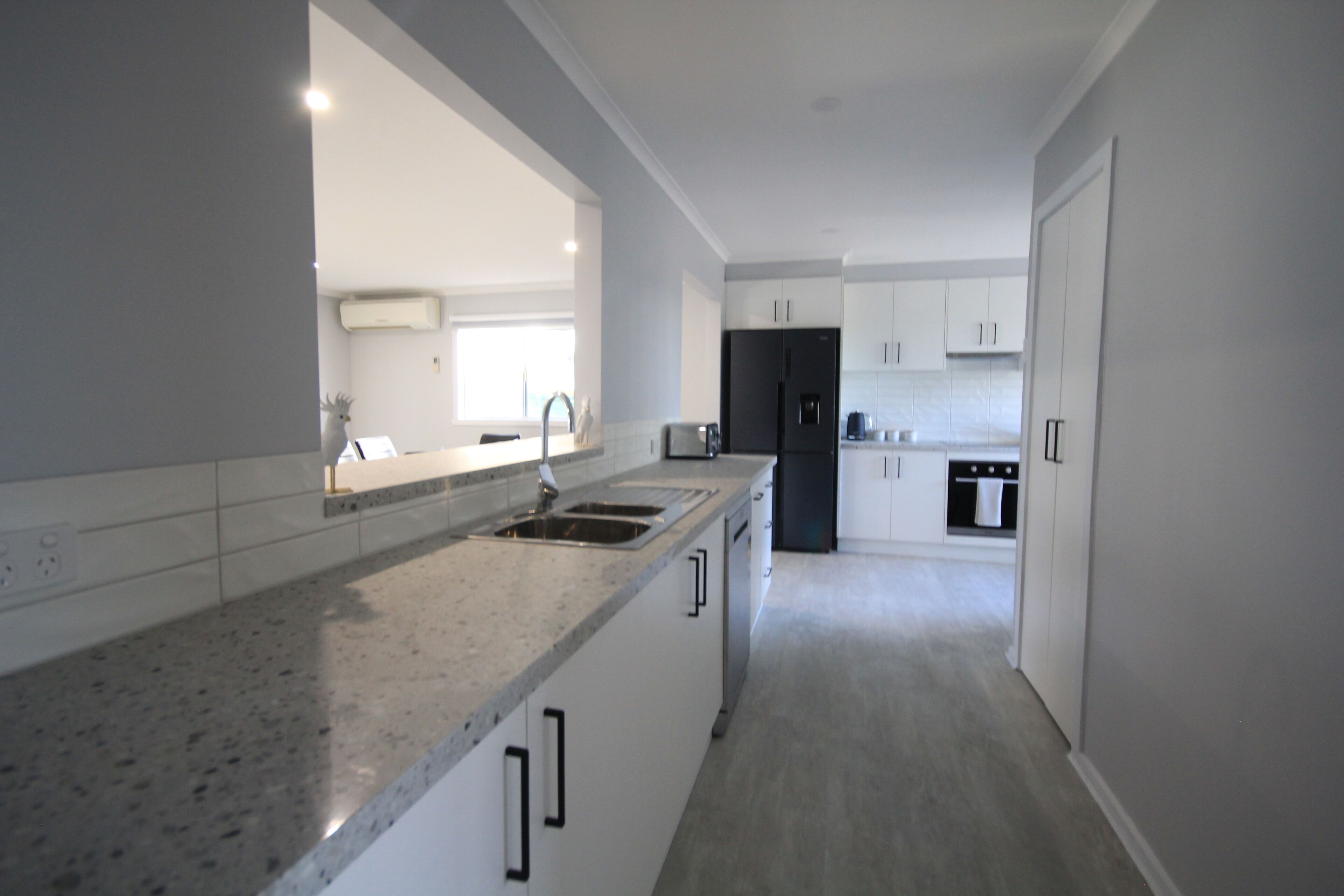 A modern kitchen with a granite countertop, stainless steel sink, and a built-in oven.