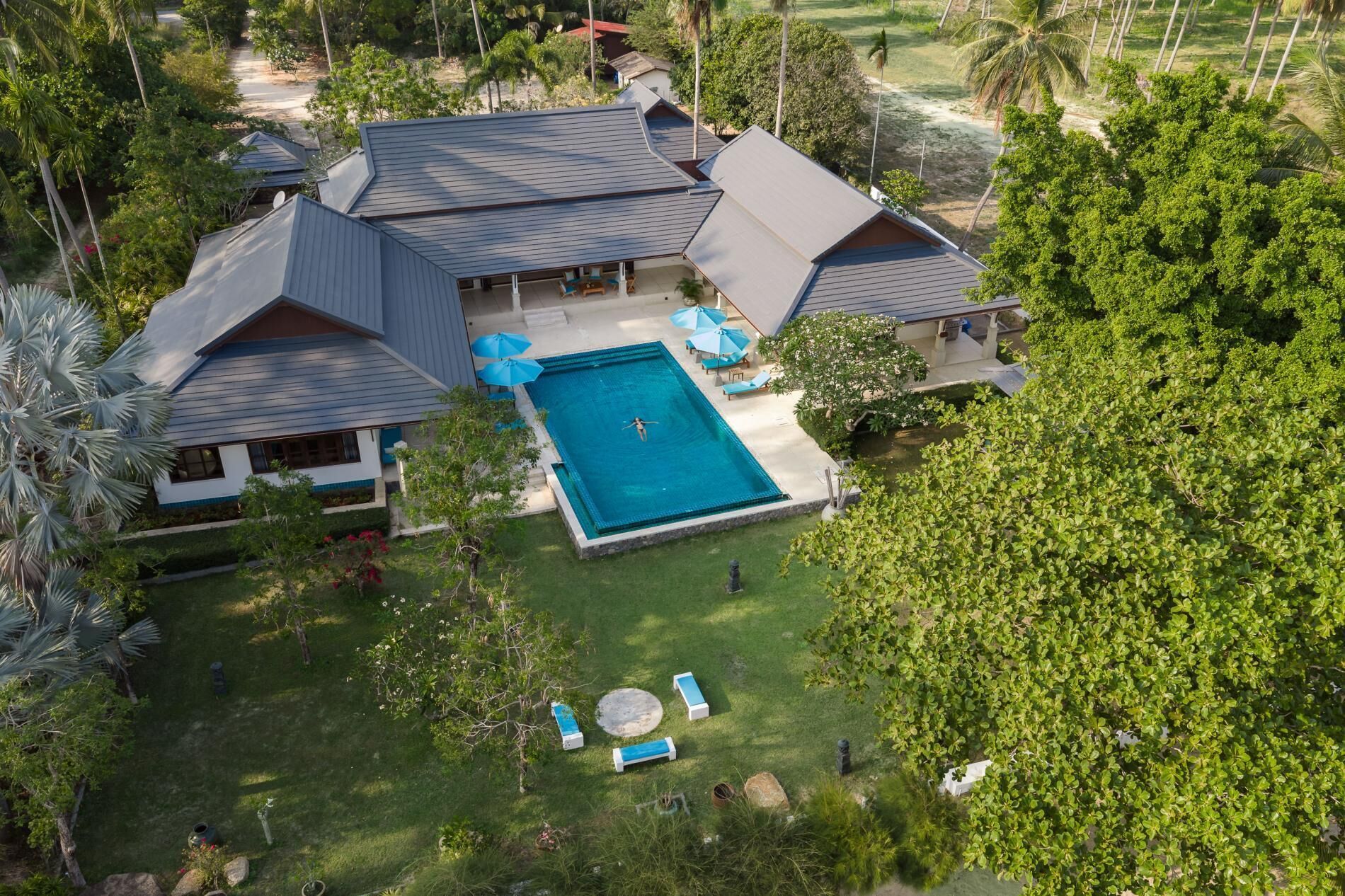 Una casa grande con piscina, varias habitaciones y un jardín bien cuidado.