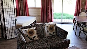 A cozy room with a sofa, a bed, and a table. - Dreamcatcher Bungalow 20min to W.Glacier, between Glacier&Airport (Columbia Falls)