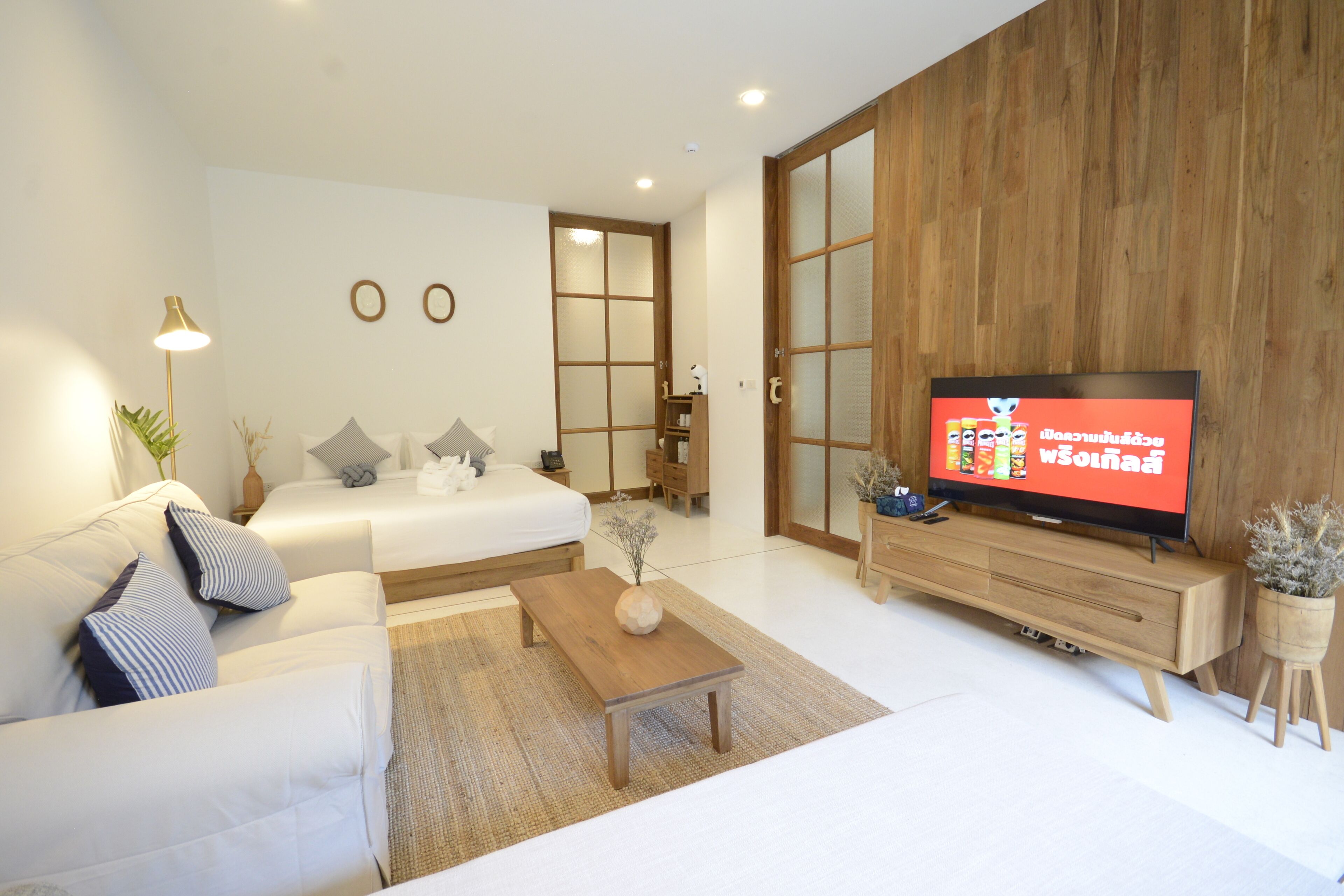 Uma sala de estar moderna com um sofá, uma mesa de centro, uma TV e um armário de madeira.