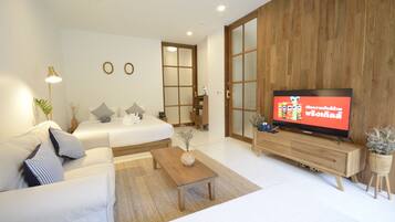 Uma sala de estar moderna com um sofá, uma mesa de centro, uma TV e um armário de madeira.
