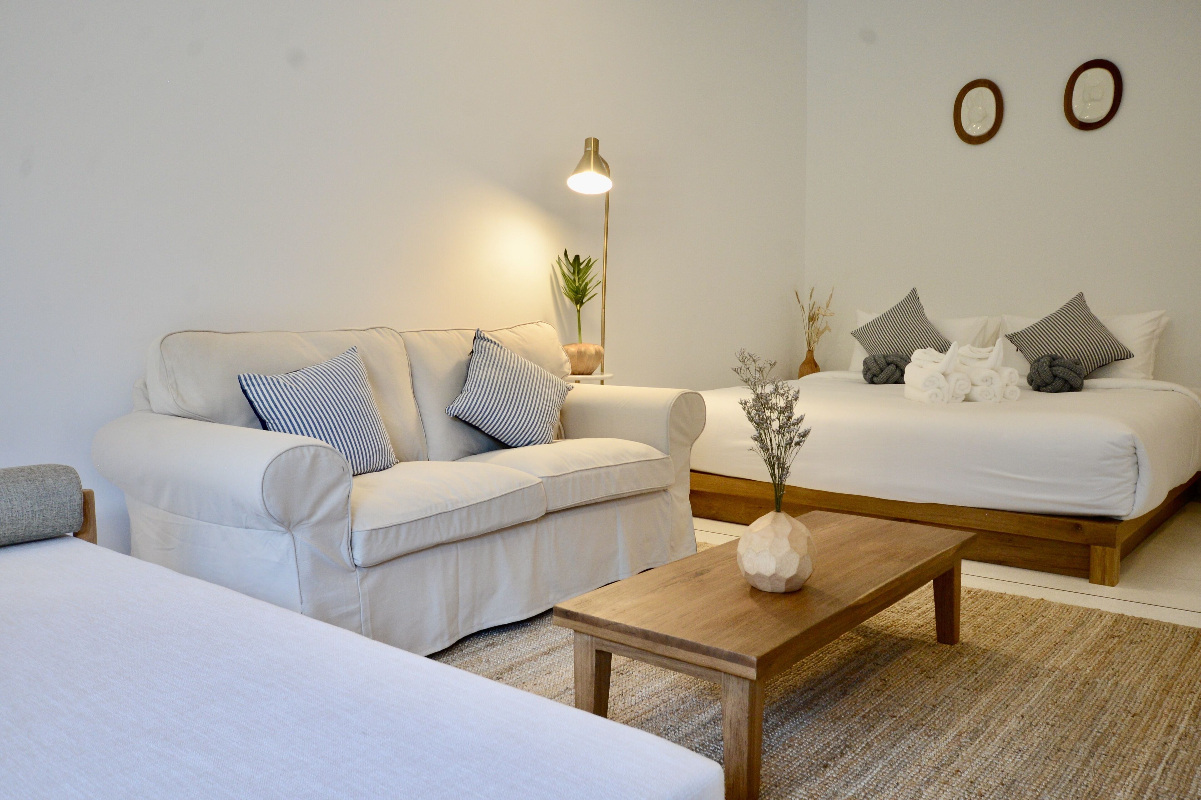 Un salon moderne et bien éclairé, avec un canapé, un lit et une table basse.