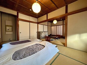 Une pièce de style japonais traditionnel, avec un sol recouvert de tatamis, un plafond bas en bois et des panneaux coulissants en papier de riz (shoji).