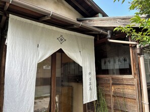 Il s’agit d’un bâtiment japonais traditionnel, doté d’une façade en bois, d’un paravent coulissant de type shoji et d’un petit jardin agrémenté de bambous.