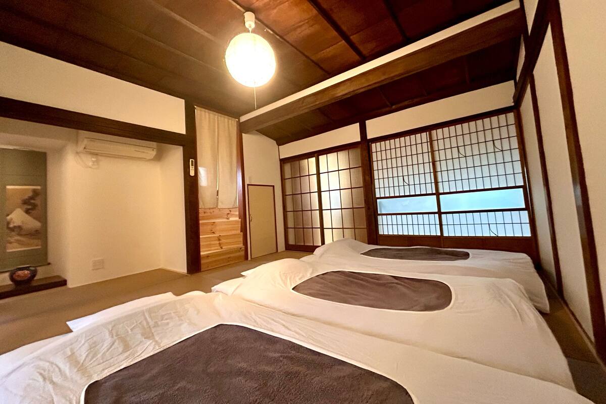 Ein traditioneller japanischer Raum mit Tatami-Boden, Shoji-Schirm und Futon.