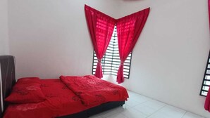 Quarto com cama, chão de azulejos brancos e cortinas vermelhas.