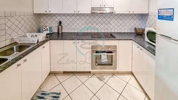 A modern kitchen with white cabinets, a built-in oven, and a microwave. - ZEN CITY MODERN - 1 BR City Apartment (Larrakeyah)