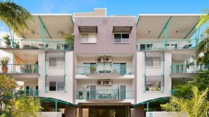 A multi-story hotel with a central entrance, balconies on each floor, and a flat roof. - ZEN CITY MODERN - 1 BR City Apartment (Larrakeyah)