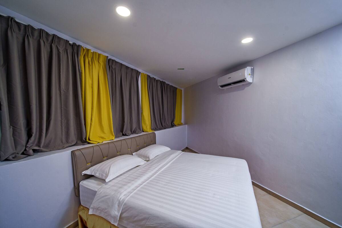 Ein Schlafzimmer mit Bett, Vorhängen, einer Klimaanlage und einer Deckenleuchte.