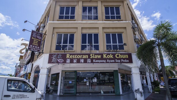 Hotelli, jonka kyltissä lukee ”HOTEL UPTOWN”, ja sen alapuolella sijaitseva ravintola nimeltä ”Restoran Siw Kok Chun”.