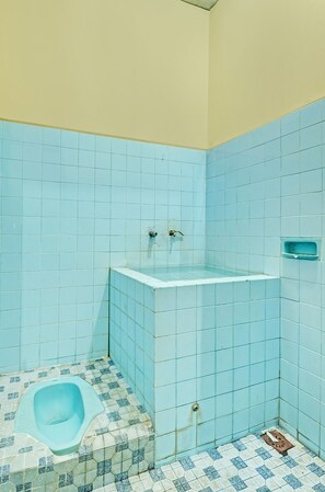A bathroom with blue tiles, a toilet, and a sink. - SPOT ON 92408 Hotel Renata 2 (Getasan)