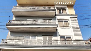 A multi-story building with a sign for 'UPHAAR PROPERTIES' and a contact number. - Covie Gurgaon 42 (Gurugram)
